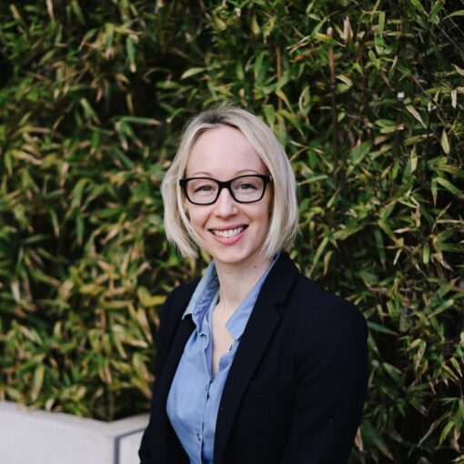 Rebecca wearing a suit siting and smiling